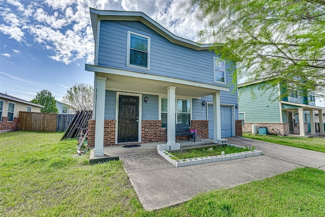 view of front of house featuring a front yard, covered porch, and a garage