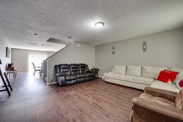 living room with dark hardwood / wood-style floors and a textured ceiling