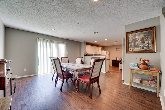 dining area with hardwood / wood-style floors and a textured ceiling