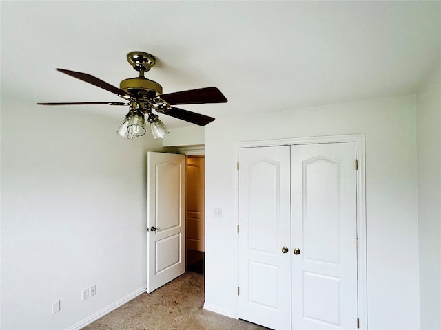 unfurnished bedroom with light colored carpet, a closet, and ceiling fan