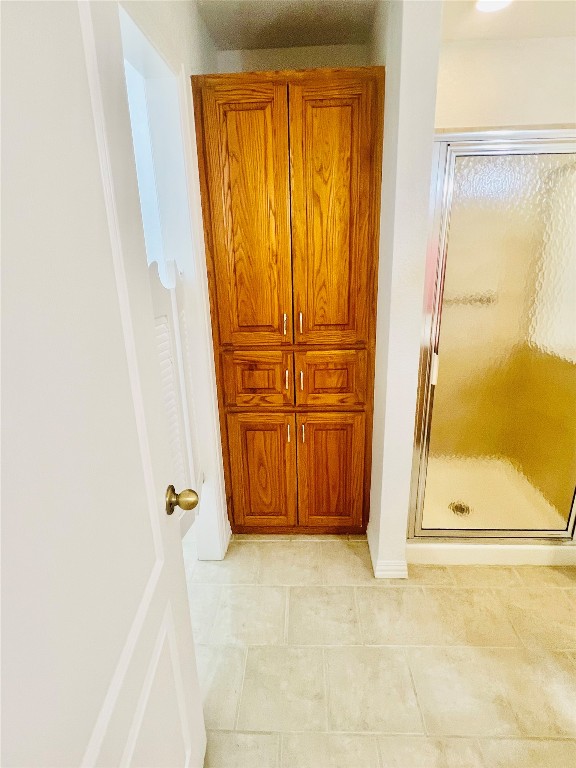 bathroom featuring walk in shower and tile flooring