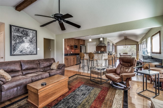 living room with light hardwood / wood-style flooring, sink, vaulted ceiling with beams, and ceiling fan with notable chandelier