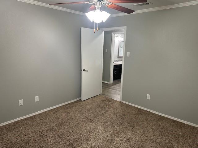 carpeted empty room with ceiling fan and ornamental molding