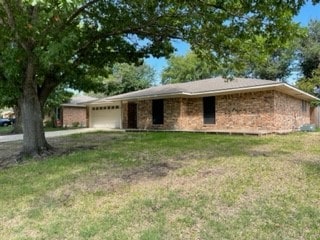 single story home featuring a garage and a front yard