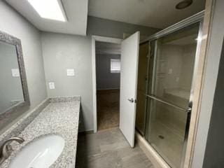 bathroom featuring vanity and a shower with door