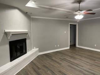 unfurnished living room with ceiling fan, dark wood-type flooring, and ornamental molding