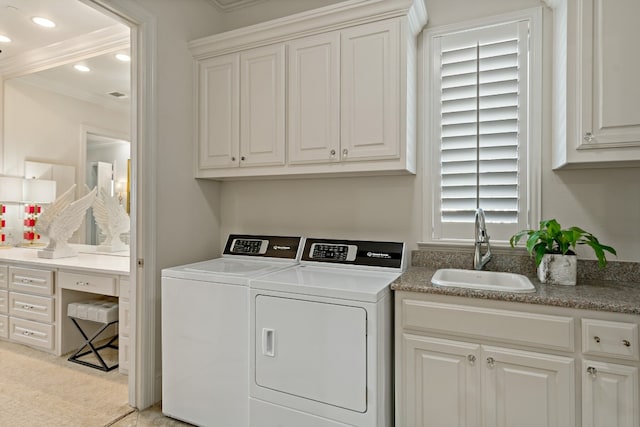 laundry room featuring crown molding, cabinets, sink, and washer and dryer