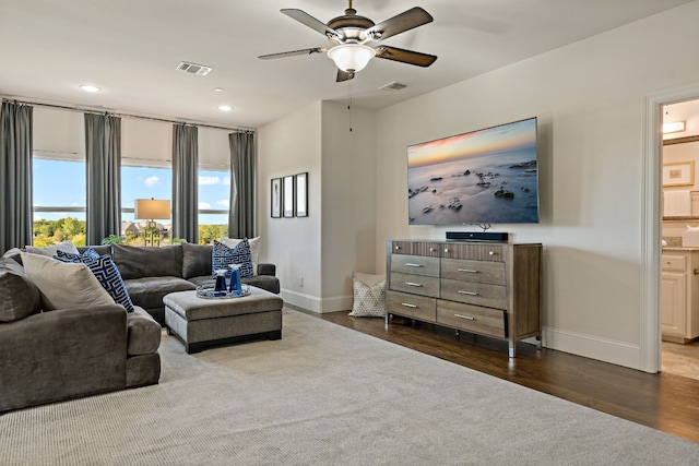 living room featuring dark hardwood / wood-style flooring and ceiling fan