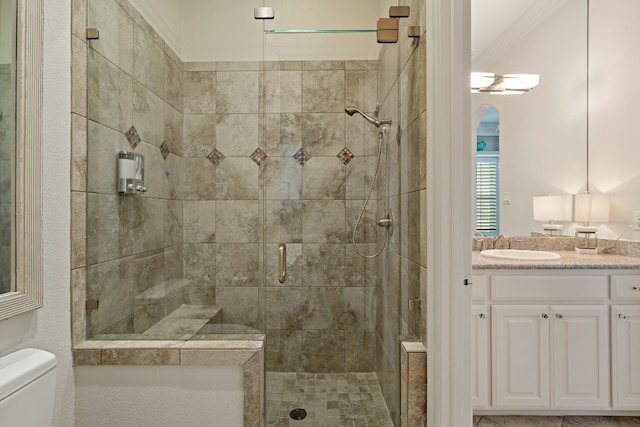 bathroom featuring vanity, toilet, crown molding, and walk in shower