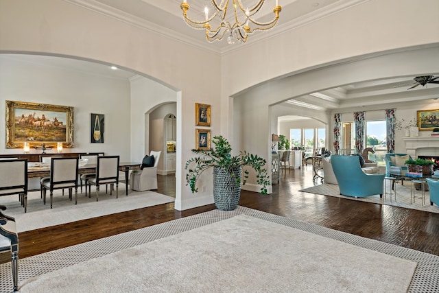 entryway featuring a notable chandelier, crown molding, dark wood-type flooring, and a raised ceiling