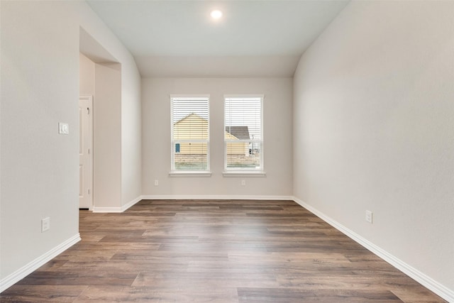 unfurnished room with dark wood-type flooring and vaulted ceiling