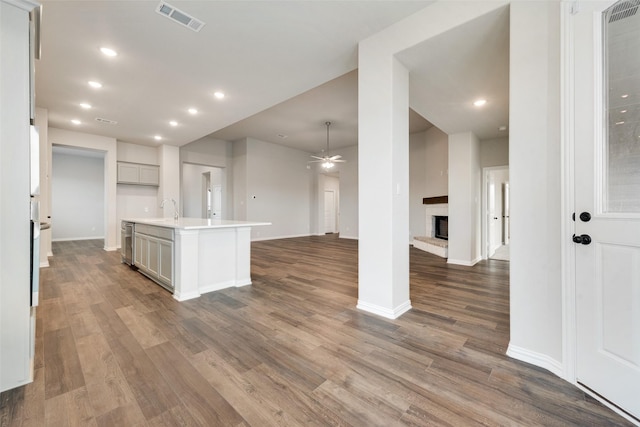 kitchen featuring dark hardwood / wood-style floors, ceiling fan, sink, and a kitchen island with sink