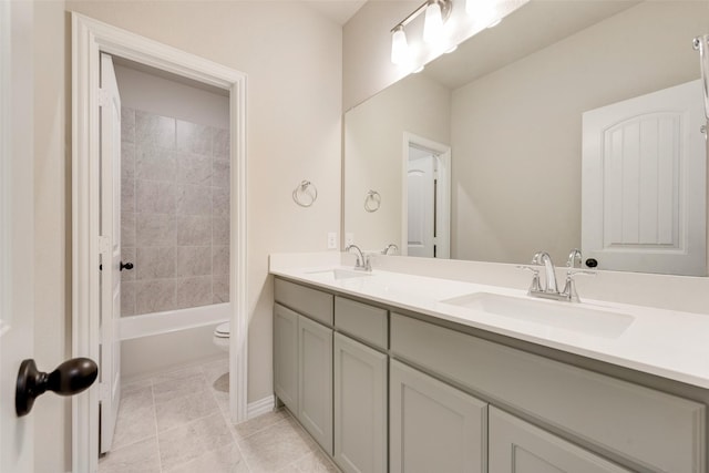 full bathroom featuring tiled shower / bath, vanity, toilet, and tile patterned flooring