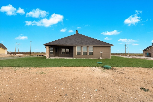 back of property with a yard and a patio area