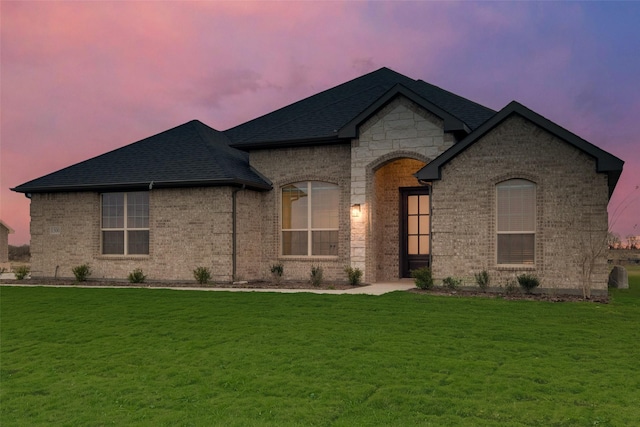 french provincial home with a lawn