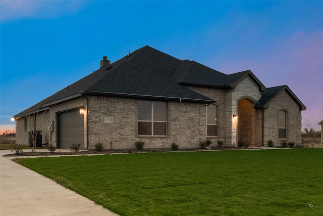 french provincial home with a garage and a yard