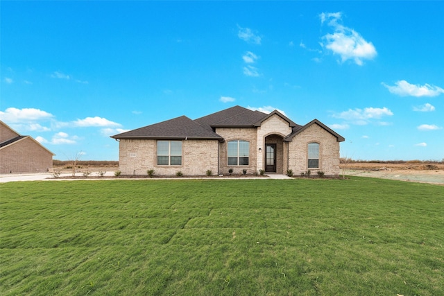 french country home featuring a front lawn