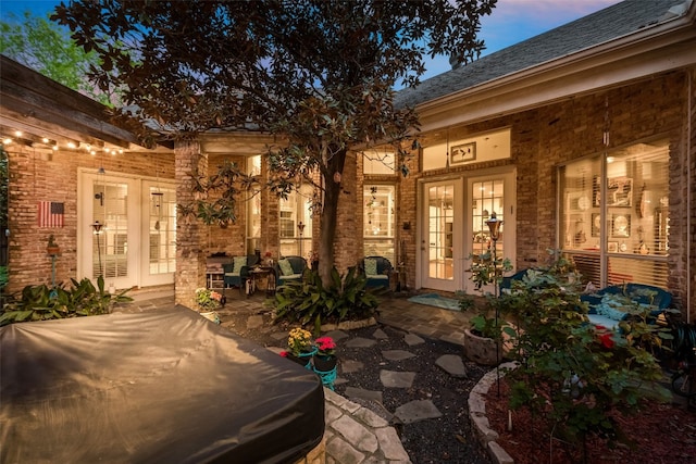 exterior entry at dusk with a patio and french doors