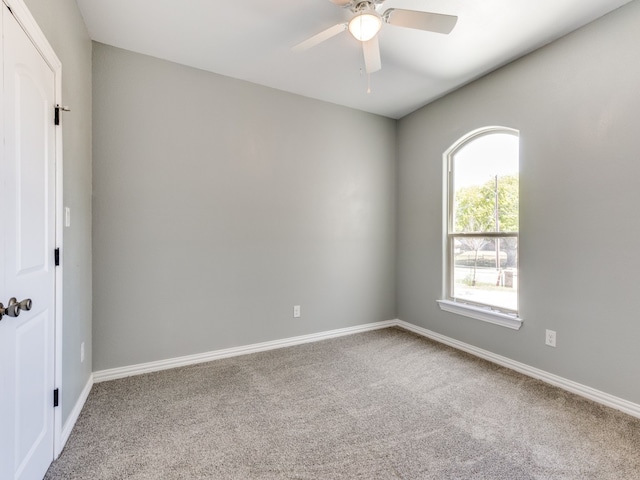 unfurnished room with light colored carpet and ceiling fan