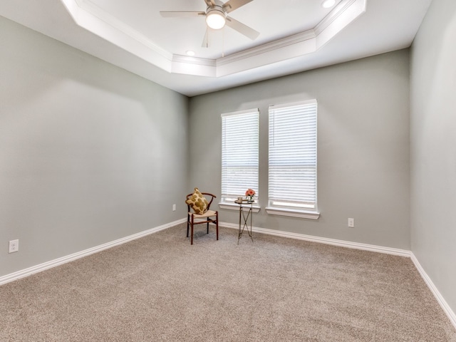 unfurnished room featuring ceiling fan, ornamental molding, a tray ceiling, and light carpet