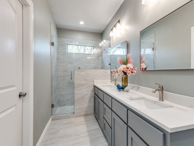 bathroom with large vanity, dual sinks, tile floors, and an enclosed shower