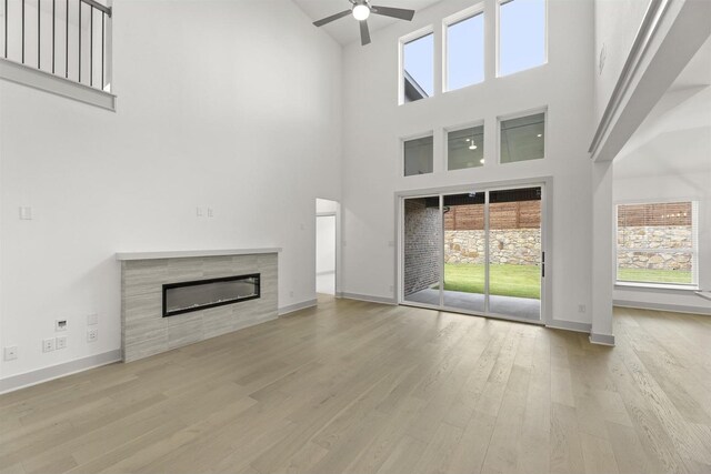 1841 Jasmine June, Mesquite, TX 75181 - unfurnished living room with ceiling fan, high vaulted ceiling, a tiled fireplace, baseboards, and wood finished floors