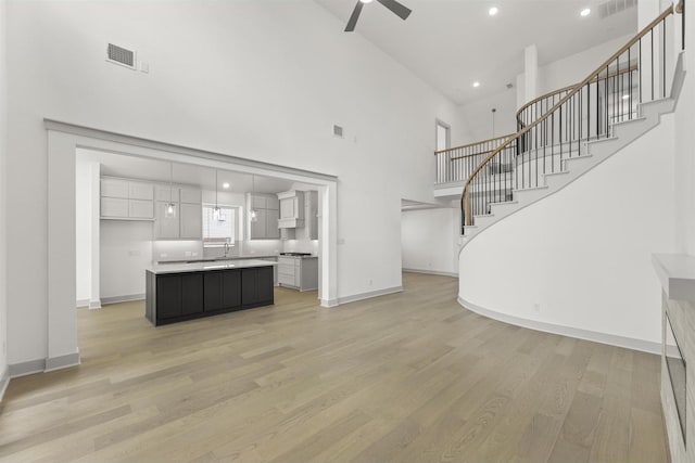 1841 Jasmine June, Mesquite, TX 75181 - unfurnished living room featuring a ceiling fan, a high ceiling, visible vents, and stairway