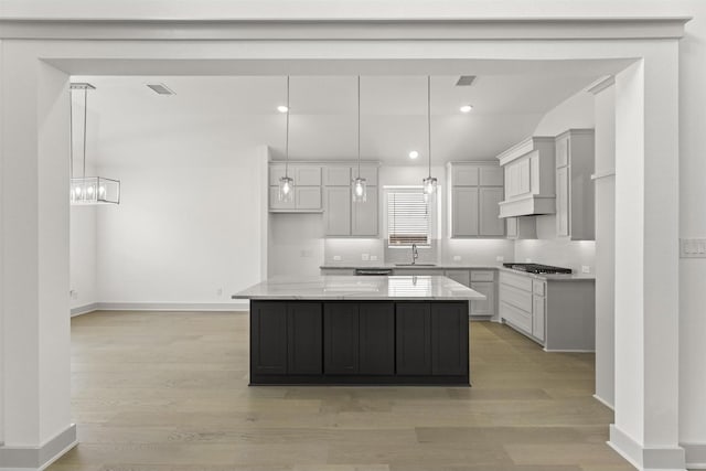 1841 Jasmine June, Mesquite, TX 75181 - kitchen with a sink, light wood-style flooring, a center island, baseboards, and stainless steel gas stovetop