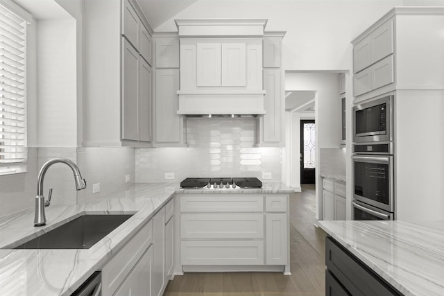 1841 Jasmine June, Mesquite, TX 75181 - kitchen featuring a sink, built in microwave, stainless steel gas stovetop, custom range hood, and backsplash