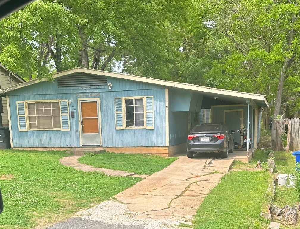 view of front facade with a front lawn and a carport