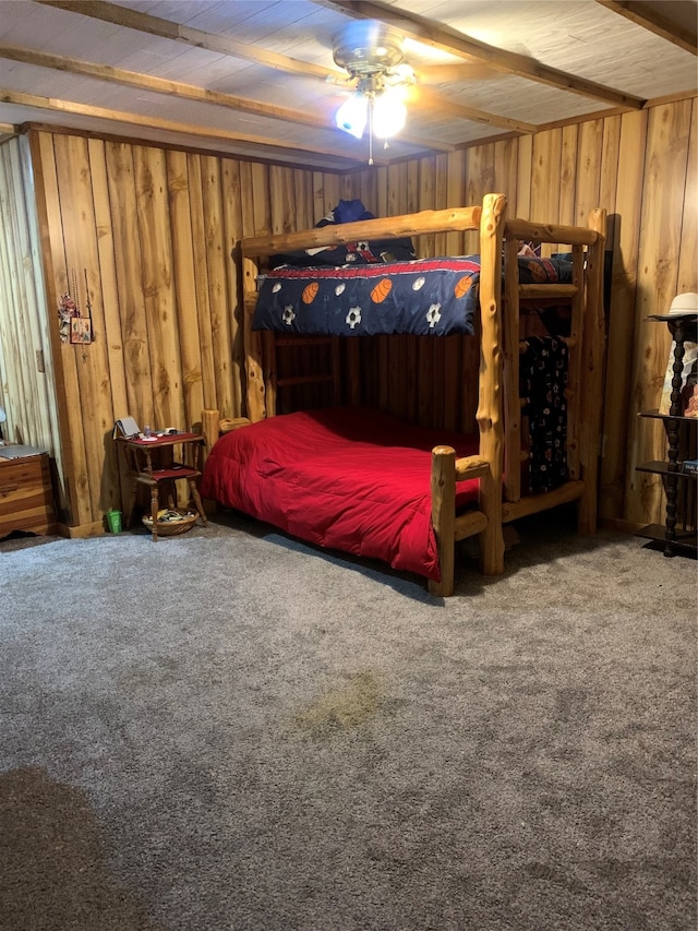 carpeted bedroom with wood walls and ceiling fan