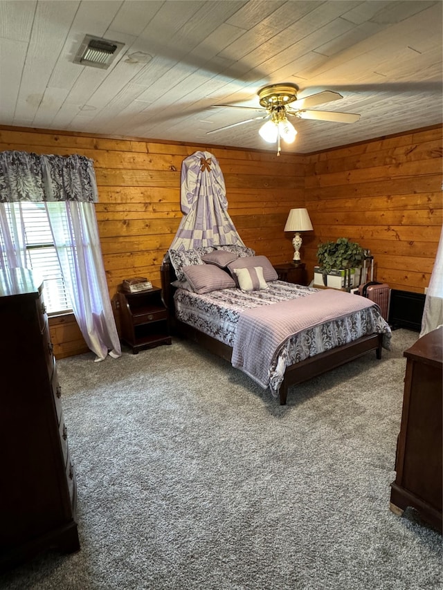 carpeted bedroom featuring wooden ceiling, wood walls, and ceiling fan