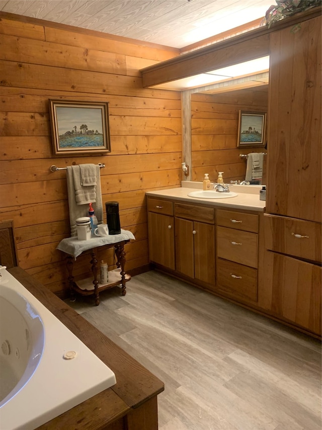 bathroom with hardwood / wood-style flooring, wooden walls, and vanity