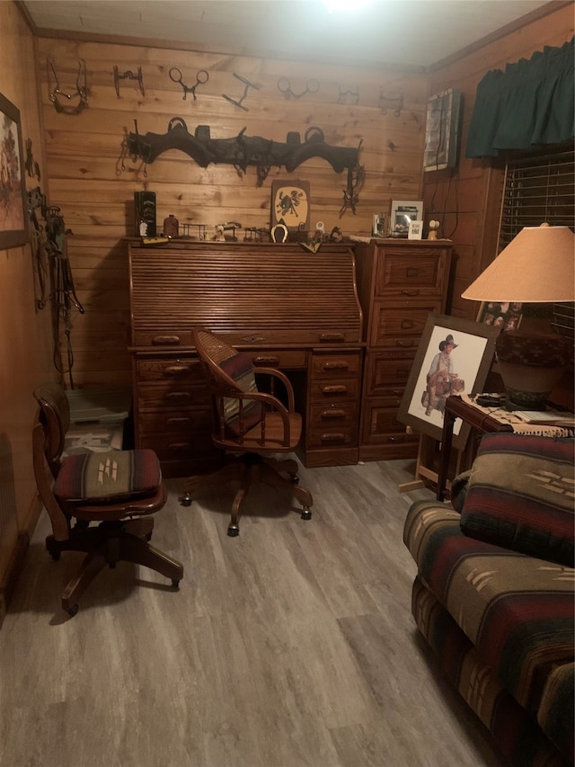 office area with light hardwood / wood-style flooring and wooden walls