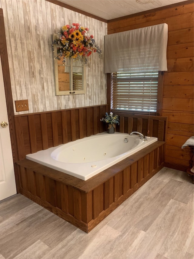 bathroom featuring wood walls, hardwood / wood-style flooring, and a tub