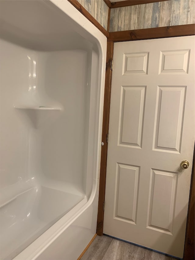 bathroom with shower / bath combination and hardwood / wood-style floors