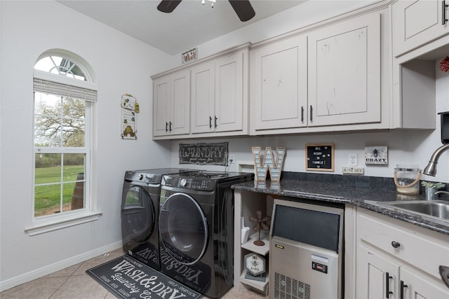 laundry area with ceiling fan, separate washer and dryer, cabinets, and a healthy amount of sunlight