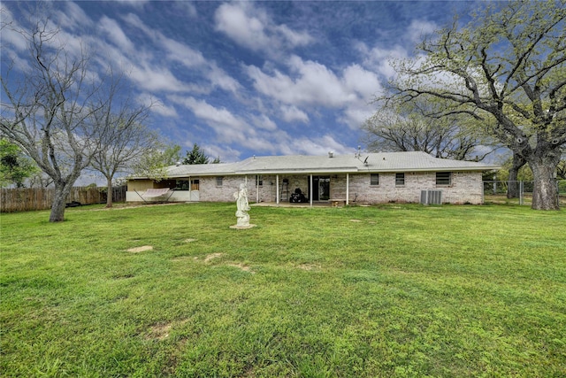 rear view of property featuring a yard, a patio, and central air condition unit