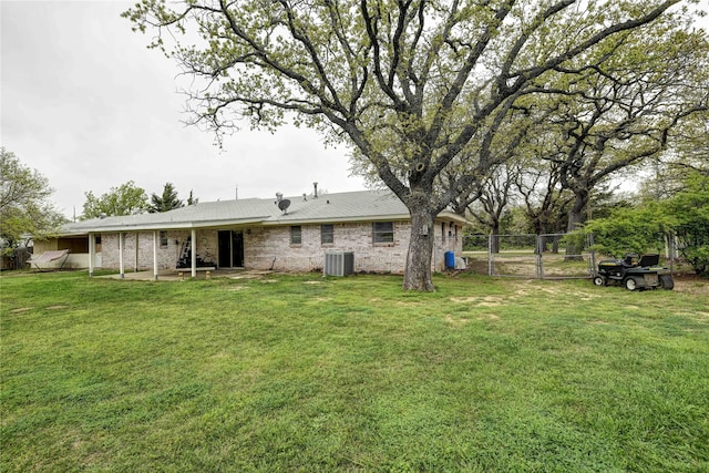 rear view of property with a lawn and central AC