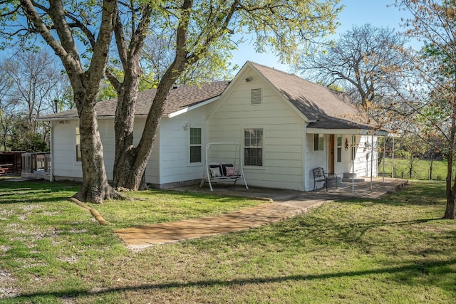 back of house featuring a lawn and a patio area