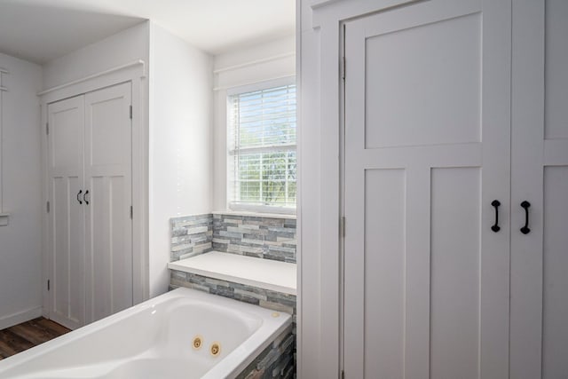 bathroom featuring wood-type flooring and tiled bath