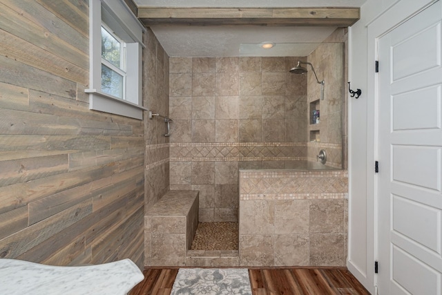 bathroom with a tile shower and hardwood / wood-style flooring