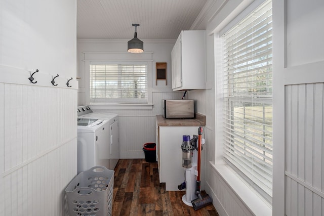 clothes washing area featuring washing machine and clothes dryer, cabinets, a healthy amount of sunlight, ornamental molding, and dark hardwood / wood-style floors