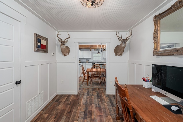 hallway featuring an inviting chandelier, ornamental molding, and dark hardwood / wood-style floors