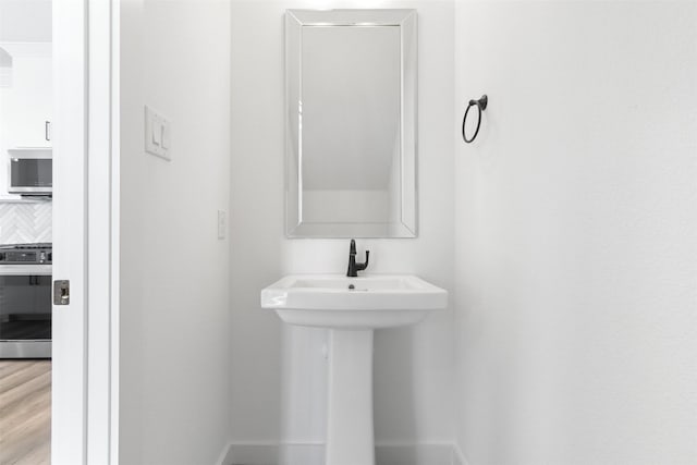 bathroom with tasteful backsplash and hardwood / wood-style floors