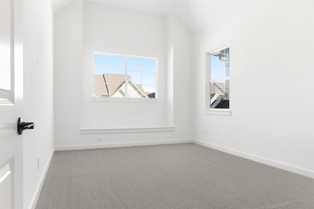 unfurnished room with lofted ceiling and carpet flooring