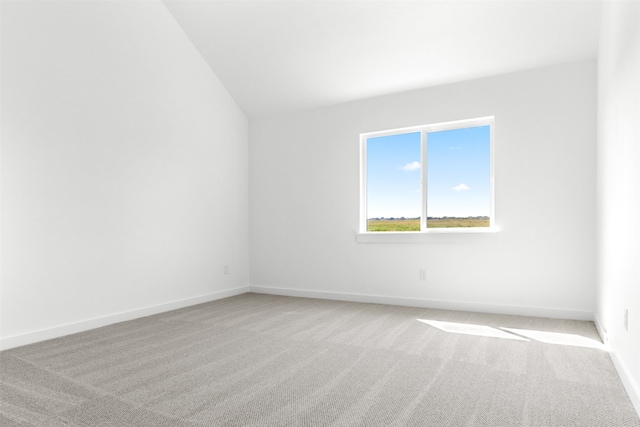 empty room with lofted ceiling and light colored carpet