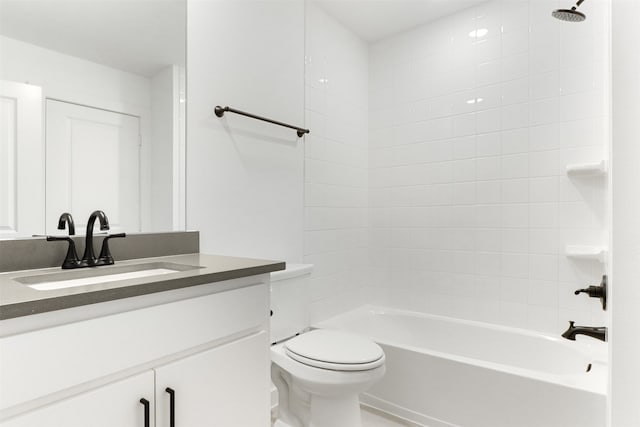 full bathroom with vanity, tiled shower / bath combo, and toilet