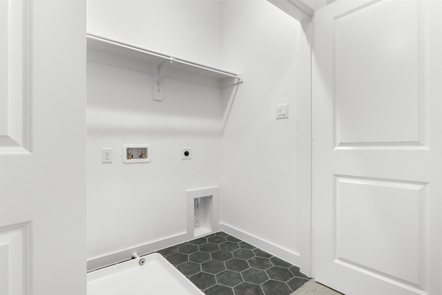 laundry area featuring hookup for a washing machine, dark tile patterned flooring, and electric dryer hookup