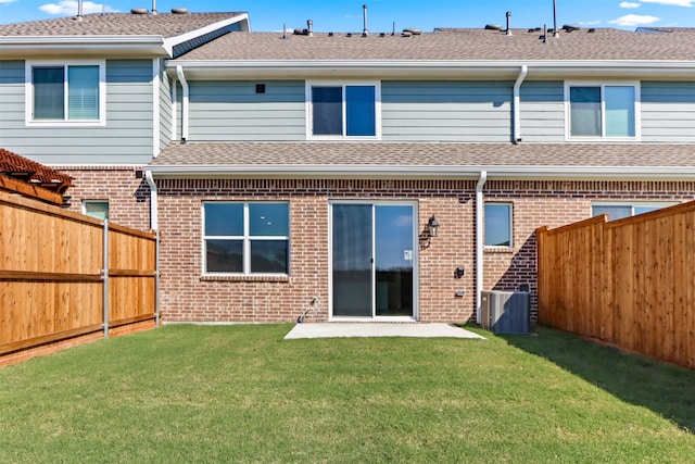 rear view of house with a lawn and central AC unit